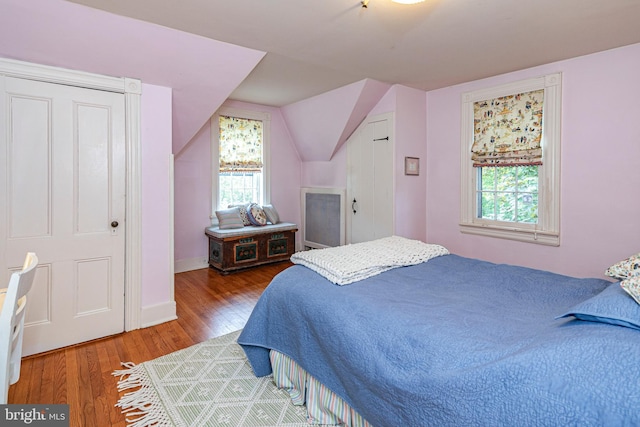 bedroom featuring hardwood / wood-style flooring, multiple windows, and lofted ceiling