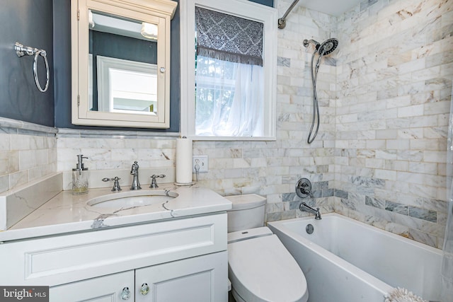 full bathroom featuring tile walls, tiled shower / bath combo, tasteful backsplash, toilet, and vanity