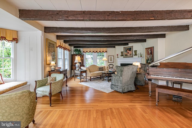 living room with a wealth of natural light, wood-type flooring, and beam ceiling