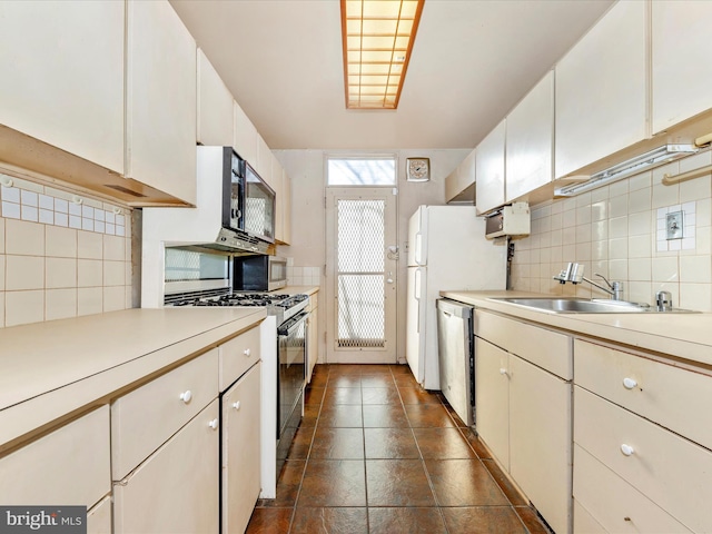 kitchen with decorative backsplash, sink, white cabinets, and appliances with stainless steel finishes