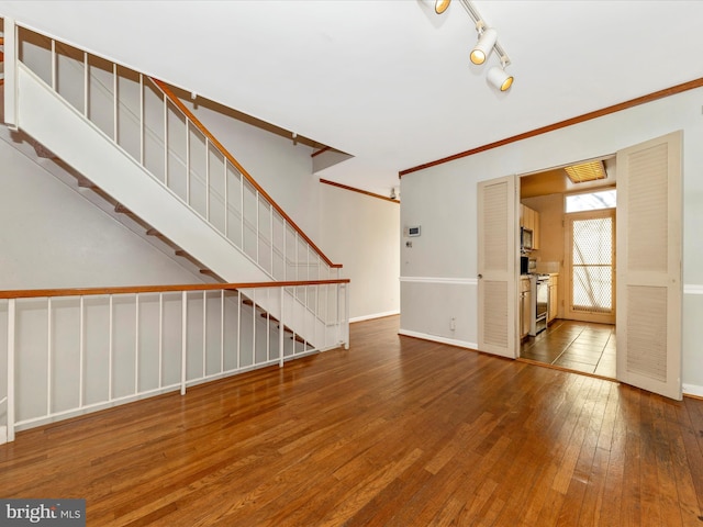 unfurnished living room featuring hardwood / wood-style floors and ornamental molding