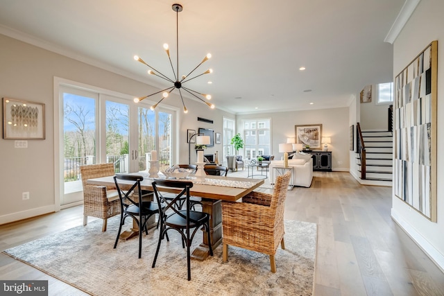 dining space featuring crown molding, a notable chandelier, and light wood-type flooring