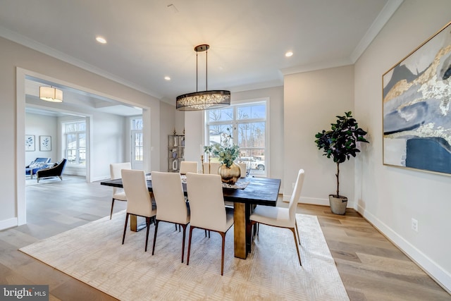 dining space featuring light hardwood / wood-style flooring, an inviting chandelier, and ornamental molding