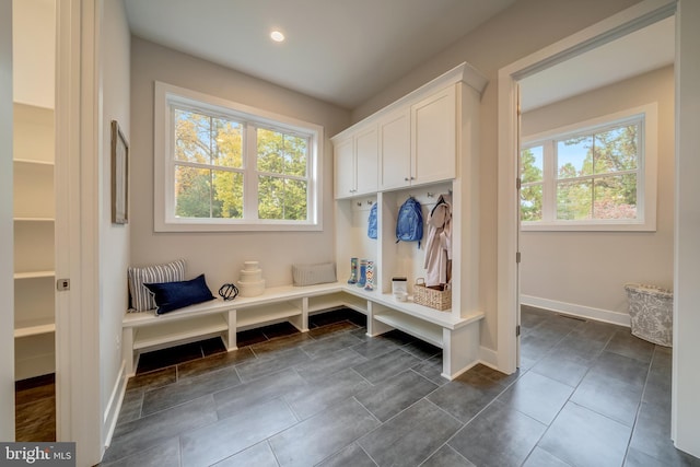 mudroom featuring dark tile floors and a healthy amount of sunlight