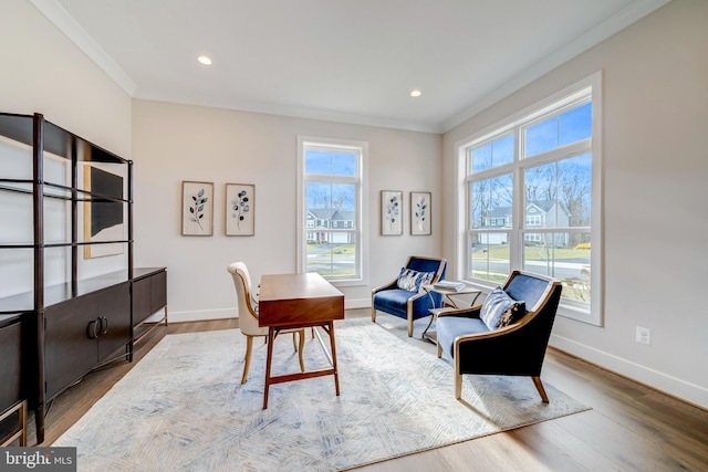 living area with light hardwood / wood-style flooring, ornamental molding, and plenty of natural light