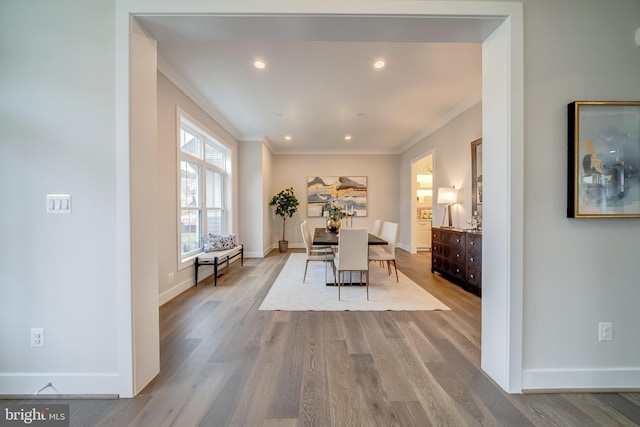 dining room with ornamental molding and light wood-type flooring