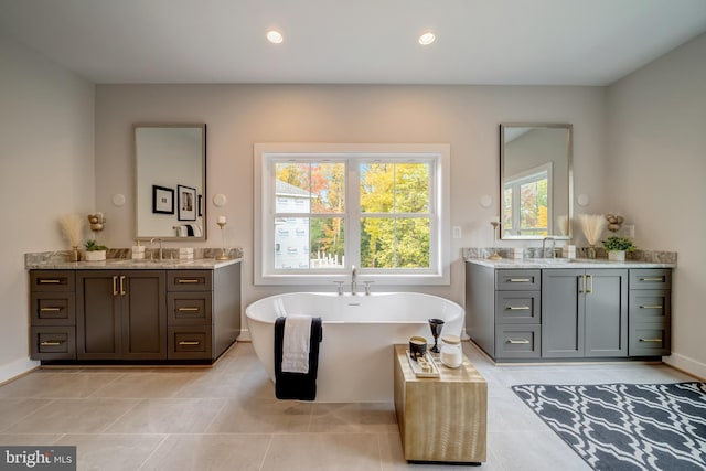 bathroom featuring dual sinks, large vanity, and tile flooring