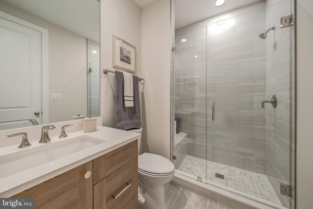 bathroom with toilet, a shower with door, large vanity, and tile floors