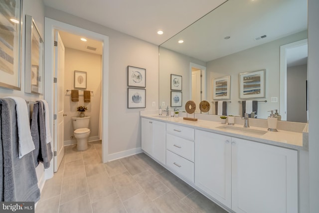 bathroom featuring toilet, vanity with extensive cabinet space, tile flooring, and dual sinks