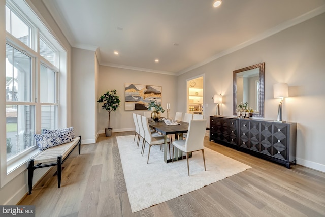 dining room with crown molding and light hardwood / wood-style flooring