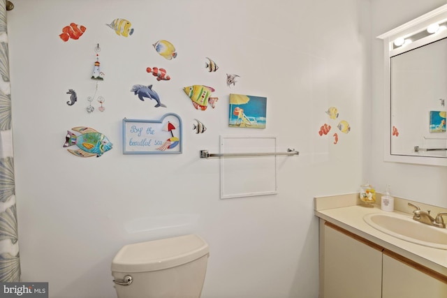 bathroom featuring vanity with extensive cabinet space and toilet