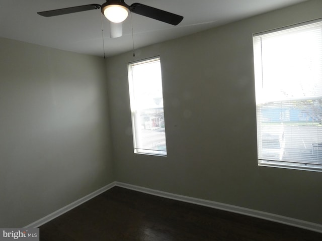 unfurnished room featuring dark hardwood / wood-style floors, plenty of natural light, and ceiling fan