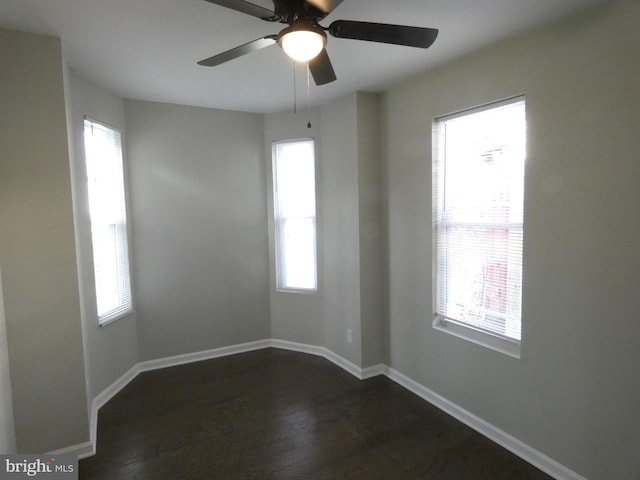 empty room featuring dark hardwood / wood-style flooring, plenty of natural light, and ceiling fan