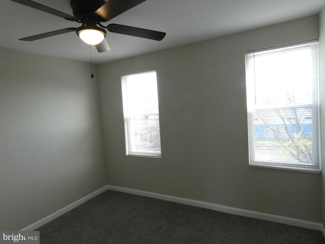 carpeted spare room featuring ceiling fan