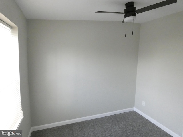 unfurnished room with dark colored carpet and ceiling fan