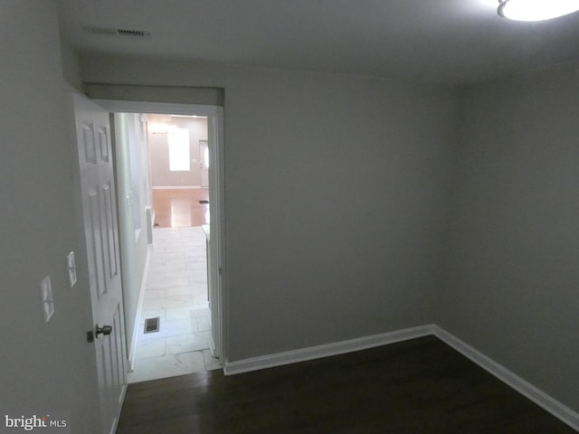 spare room featuring dark tile flooring