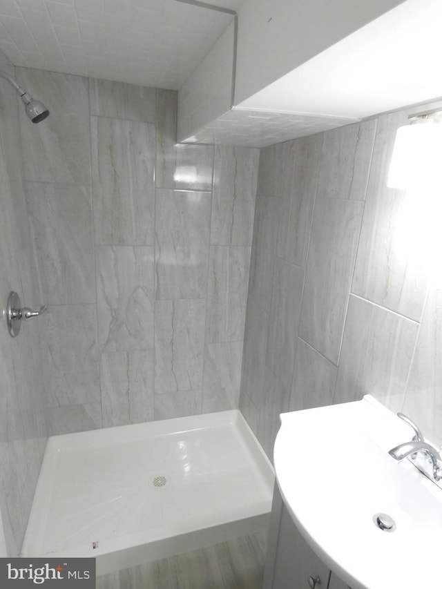 bathroom featuring sink and a tile shower