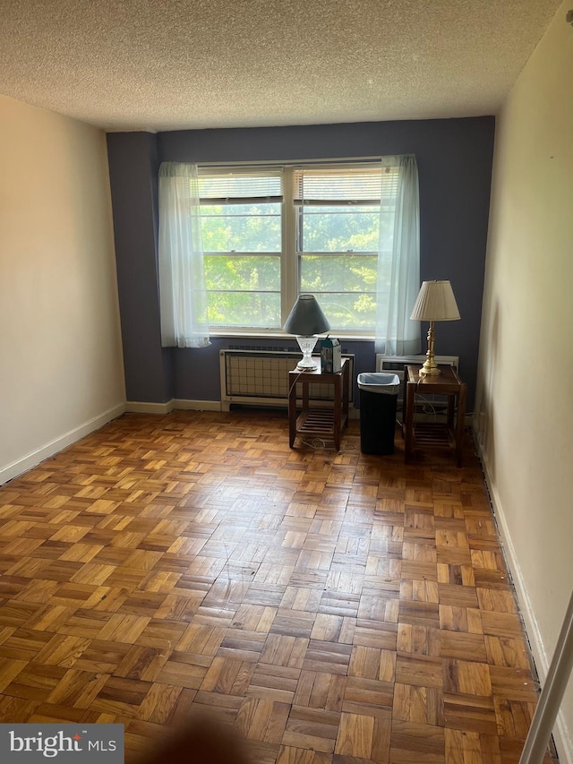 living area featuring parquet floors and a textured ceiling