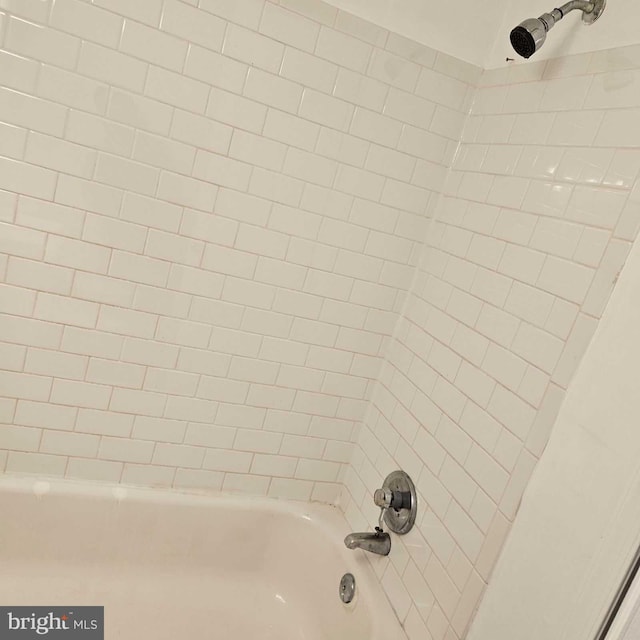 interior details featuring tiled shower / bath combo