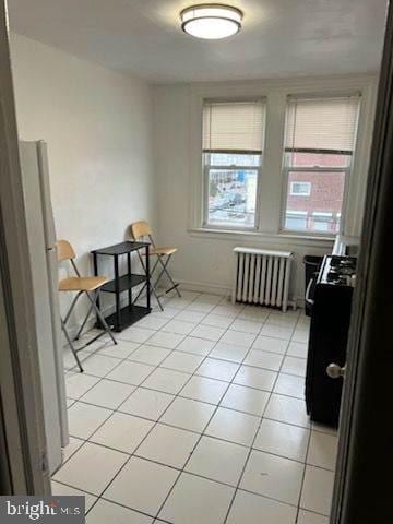 interior space with light tile patterned floors and radiator