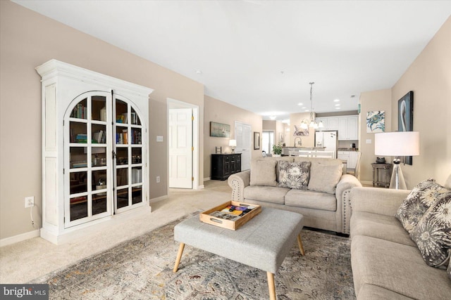 living room with light colored carpet and a chandelier