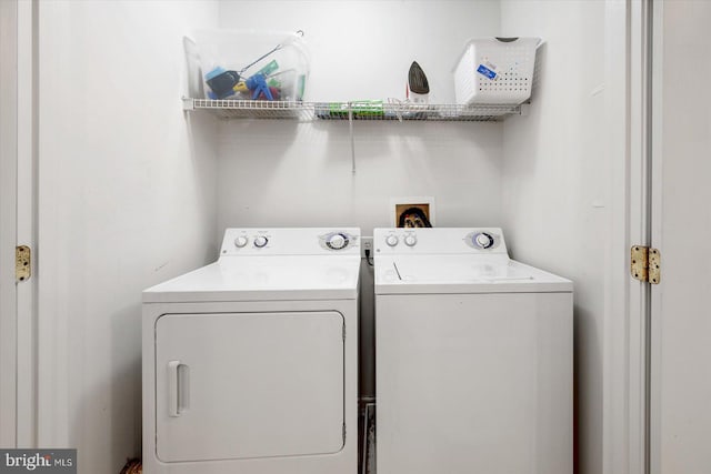 clothes washing area with washer hookup and washer and clothes dryer