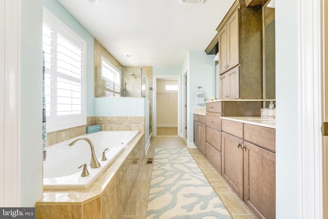 bathroom with shower with separate bathtub, tile flooring, and vanity with extensive cabinet space