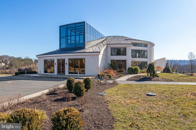 view of front of property featuring a front yard and french doors