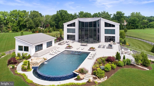 view of pool with a lawn and a patio