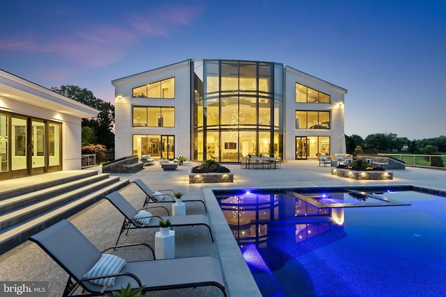 pool at dusk featuring a patio