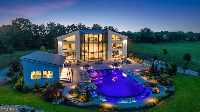 exterior space featuring a pool with hot tub, a patio, and a yard