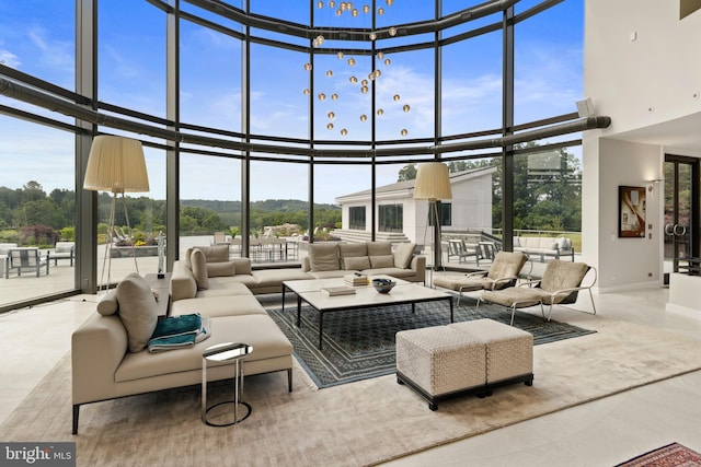 tiled living room with expansive windows, a healthy amount of sunlight, and a towering ceiling