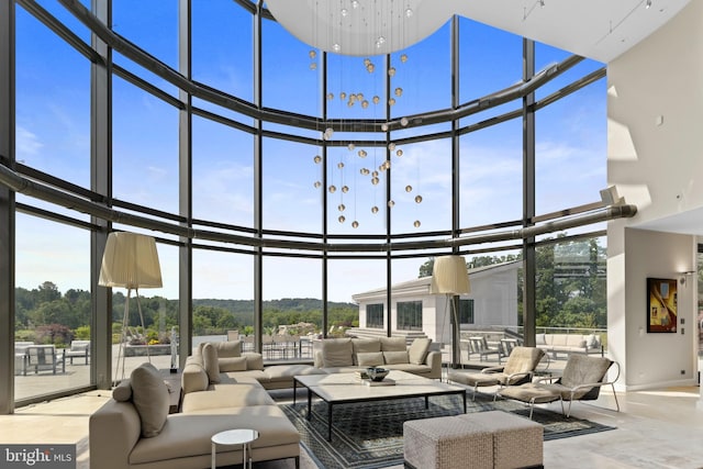 living room featuring expansive windows, plenty of natural light, and a towering ceiling