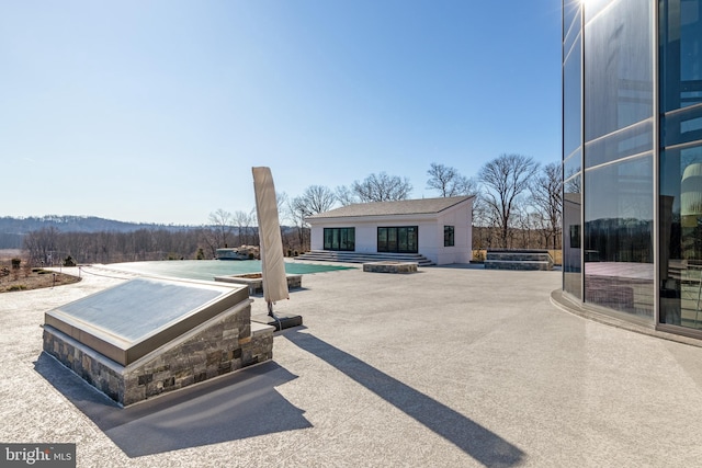 exterior space with a pool with hot tub and a patio area