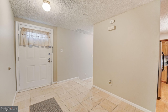 tiled foyer with a textured ceiling