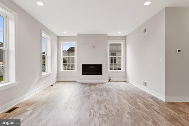 unfurnished living room with plenty of natural light and light wood-type flooring