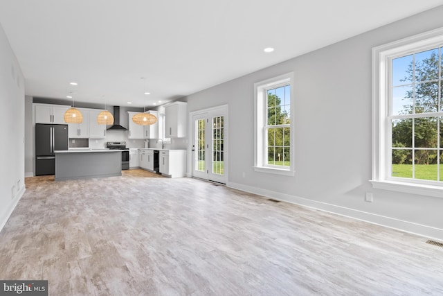 unfurnished living room with light hardwood / wood-style flooring and sink