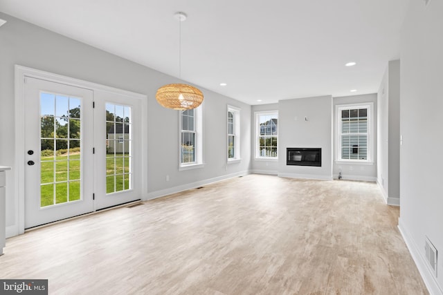 unfurnished living room featuring light hardwood / wood-style flooring and a healthy amount of sunlight