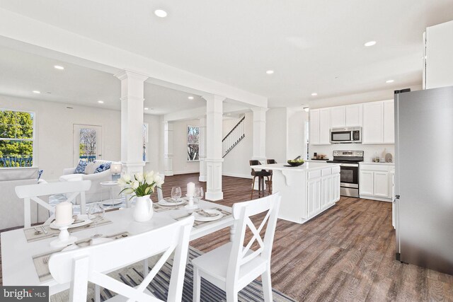 dining room featuring decorative columns and hardwood / wood-style floors