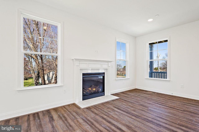 unfurnished living room with plenty of natural light and dark hardwood / wood-style floors