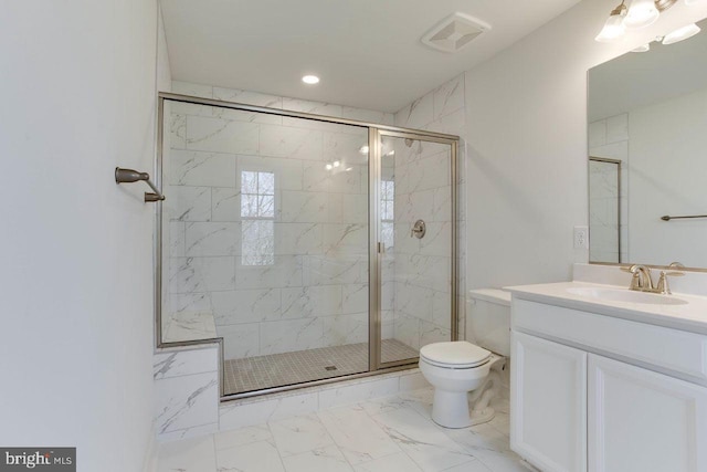 bathroom with vanity, a shower with shower door, and toilet