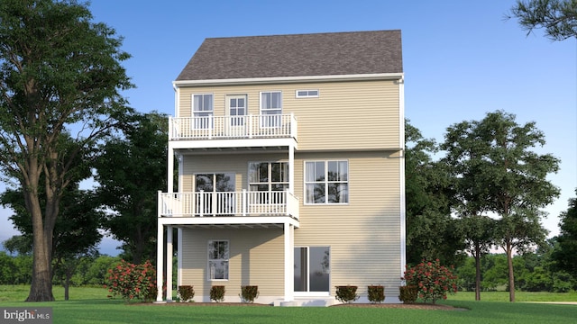 rear view of house with a lawn and a balcony