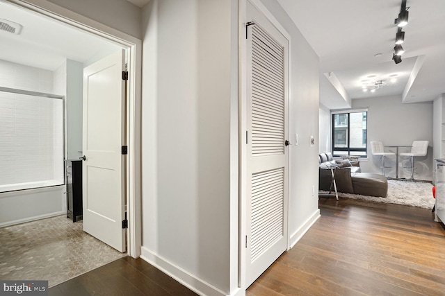 hall featuring wood-type flooring and track lighting