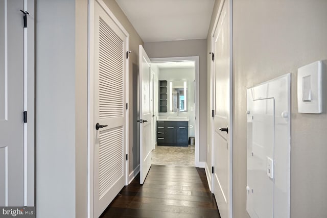 corridor with dark wood-type flooring and sink