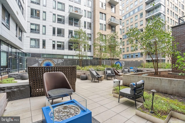 view of patio / terrace featuring a balcony and an outdoor fire pit