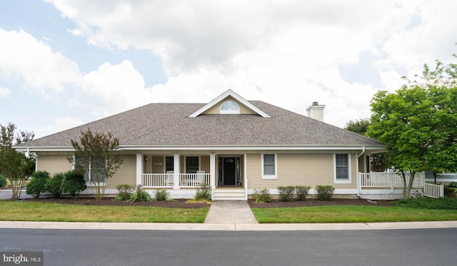 view of front of property featuring covered porch and a front lawn