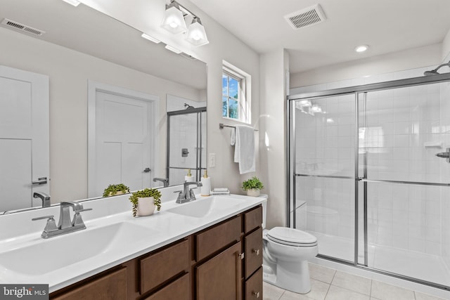 bathroom with tile floors, toilet, dual vanity, and an enclosed shower