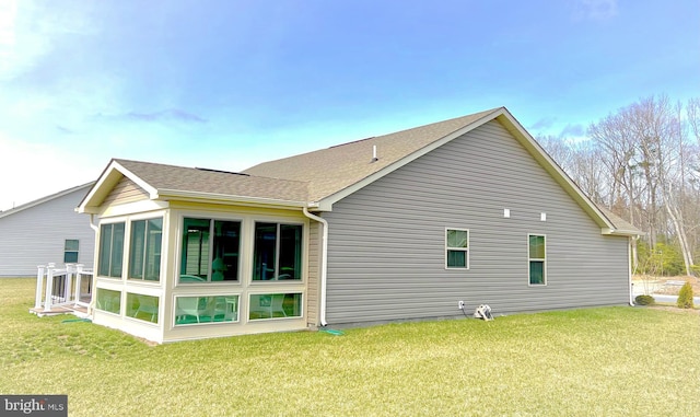 back of property featuring a sunroom and a yard