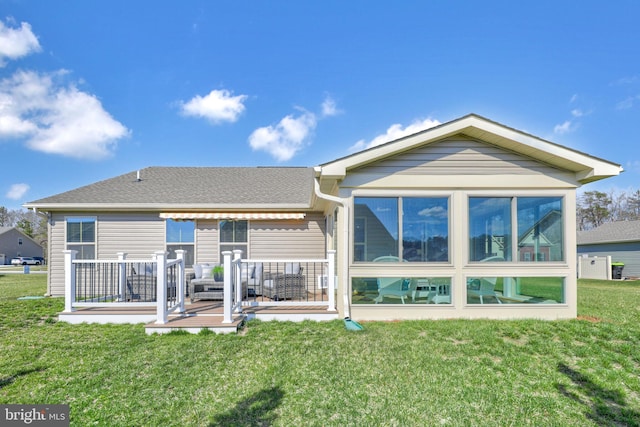 back of property featuring a deck and a yard