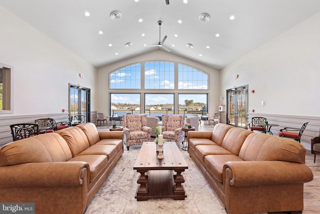 living room featuring ceiling fan, light wood-type flooring, and high vaulted ceiling